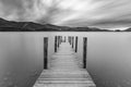 Jetty at lake with moody sky.