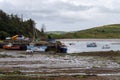 An jetty and several moored fishing boats in Clonakilty Bay. Fishing boats anchored at low tide