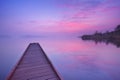 Jetty on a still lake at dawn in The Netherlands