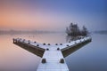 Jetty on a still lake on a foggy winter's morning