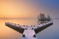 Jetty on a still lake on a foggy winter's morning