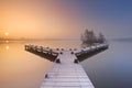 Jetty on a still lake on a foggy winter's morning