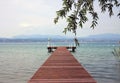 Jetty with tree in foreground, Lake Garda Royalty Free Stock Photo