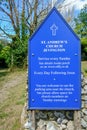 Blue wooden sign for St. Andrew`s Church in Jevington, Sussex