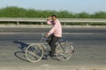 man rides bicycle at the Yamuna express highway in India