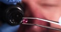 Jeweler checks gemstones for authenticity through magnifying glass.