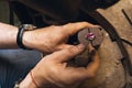 Jeweler fixes the stone in the setting of a gold ring, close-up