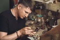 The jeweler inspects the gold ring for defects in his workshop