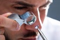 Jeweler Looking At Diamond Through Magnifying Loupe