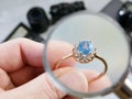 Jeweler looking at ring with blue stone, jewerly inspect and verify, pawnshop concept, jewerly shop Royalty Free Stock Photo