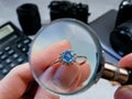 jeweler looking at ring with blue stone tourmaline paraiba, jewerly inspect and verify, pawnshop concept, jewerly shop, closeup Royalty Free Stock Photo