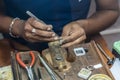 Jeweler making handmade jewelry on vintage workbench.