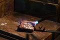 Jeweler is melting gold and silver granules in a crucible with a