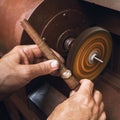 A jeweler polishes a gold ring on a machine in a workshop