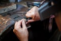 Jeweler polishes gold ring on old workbench in jewelry workshop