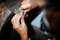 Jeweler polishes gold ring on old workbench in jewelry workshop