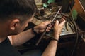 A jeweler repairs a gold diamond ring in his workshop, working process Royalty Free Stock Photo