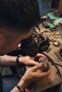 A jeweler under a microscope examines defects on a gold ring with a diamond Royalty Free Stock Photo