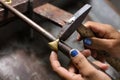 Jeweler working with the hammer on gold ring in his workshop. Cr Royalty Free Stock Photo