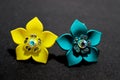 Jewellery artifact yellow,blue  flowers design earrings on black light shadow background. Royalty Free Stock Photo