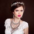 Jewellery. Beauty Fashion Model Girl with wedding elegant hairstyle. Beautiful woman with precious jewels isolated on studio dark