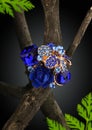 Jewellery blue ring as flower on twig, dark background Royalty Free Stock Photo