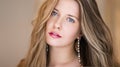 Jewellery model and beauty face closeup. Beautiful woman with blonde hair wearing luxury earrings, long hairstyle and