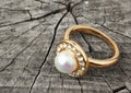 Jewellery ring with pearl on wood background
