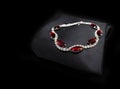 Jewellery silver ruby diamonds bracelet on black cloth background Royalty Free Stock Photo