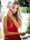 Jewelry and beauty concept - beautiful blond lady portrait in modern gems and accessories in red dress. Woman poses in Royalty Free Stock Photo