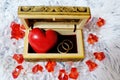 Jewelry box with a heart inside. Painted wooden box for decoration with gold rings inside. Soft fluffy backgroundr. Royalty Free Stock Photo