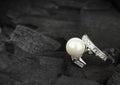 Jewelry with brilliant and pearl on black coal background, soft Royalty Free Stock Photo