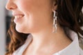 Jewelry and close-up earrings in a beautiful female ear - women& x27;s accessories, silver trendy earrings. Handmade Royalty Free Stock Photo