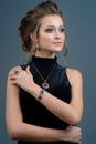 Jewelry concept. Beauty portrait of a beautiful female model posing isolated on a dark blue background Royalty Free Stock Photo