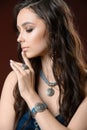 Jewelry and fashion concept. A model with earrings necklace and ring on brown background