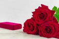 Jewelry gift box and bautiful red roses on wooden background Royalty Free Stock Photo