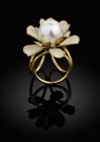 jewelry golden ring with pearl on black background with reflection