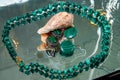 Jewelry from green malachite. Malachite beads in the studio on a glass surface with water Royalty Free Stock Photo