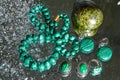 Jewelry from green malachite. Malachite beads in the studio on a glass surface with water Royalty Free Stock Photo