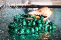 Jewelry from green malachite. Malachite beads in the studio on a glass surface with water Royalty Free Stock Photo