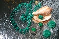 Jewelry from green malachite. Malachite beads in the studio on a glass surface with water Royalty Free Stock Photo