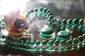 Jewelry from green malachite. Malachite beads in the studio on a glass surface with water Royalty Free Stock Photo