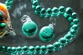 Jewelry from green malachite. Malachite beads in the studio on a glass surface with water Royalty Free Stock Photo