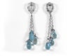 Jewelry. Long dangling earrings in white gold with natural diamonds and topaz. Royalty Free Stock Photo