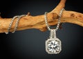 Jewelry pendant with big diamond on twig, on dark background