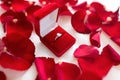 Diamond ring in red velvet gift box on bed sheet