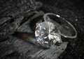 Jewelry ring with big diamond, on black coal background