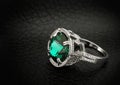 Jewelry ring with big green gem on black leather background Royalty Free Stock Photo