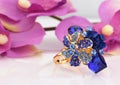 Jewelry ring with blue gems and flower background