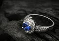 Jewelry ring witht big blue sapphir on black coal background, co Royalty Free Stock Photo